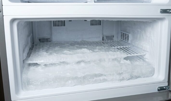 製氷機の水漏れ放置により、冷凍室の底に分厚い氷が張り、冷気の流れを妨げている状態。