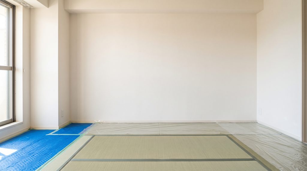 エアコン取り付け工事に備え、家具を移動してブルーシートで養生し、広く確保された作業スペース